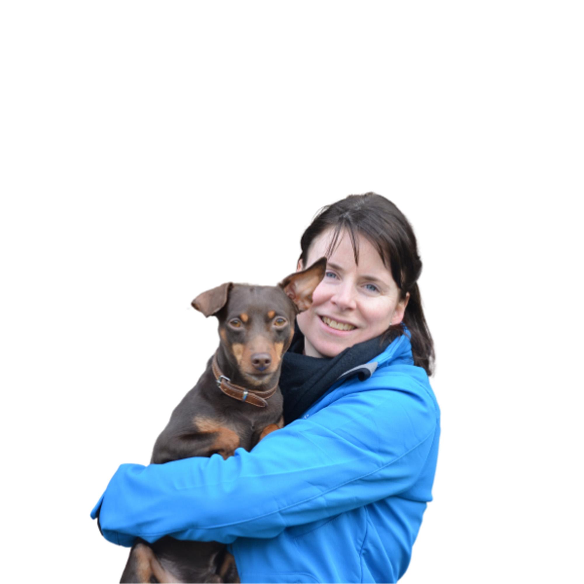 Evie Van Hove poseert met een dwerpincher Evie Van Hove poseert met een dwerpincher in haar armen tegen een blanco achtergrond.